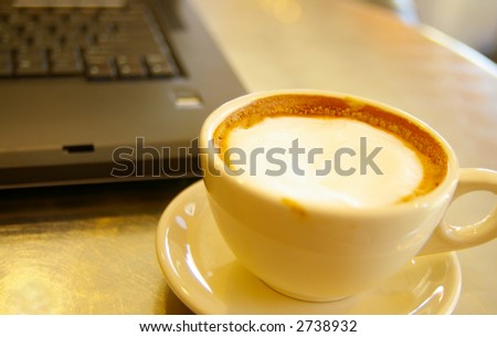Cappuccino coffee closeup, and a notebook PC