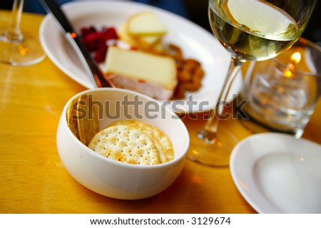 White wine with cheese and crackers on candle-lit table