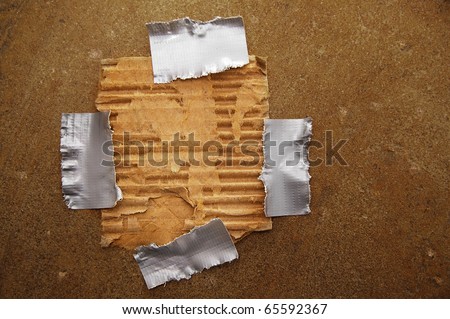 piece of ripped brown paper, taped to grunge background