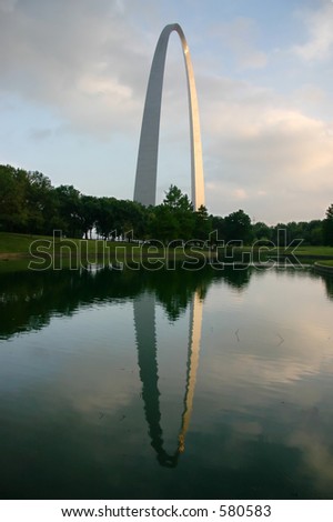 The Gateway Arch in St. Louis from the park, showing the Arch and it\'s reflection in the pond with a nice treeline.