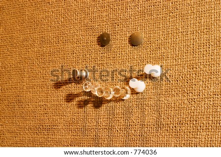 Happy / Smiley Face made of pushpins in a horizontal composition with shadows going left