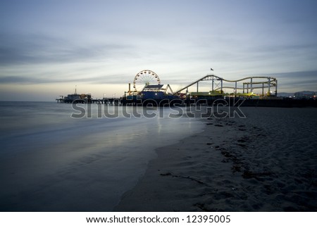 Santa Monica Beach, Santa Monica, CA May 3, 2008:  Horizontal image of the Santa Monica Pier with the prominent Ferris wheel and other thrill rides taken at dusk.