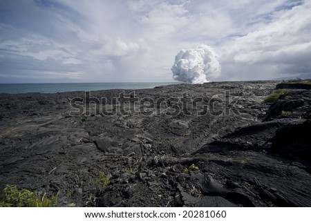 View of the steam cloud created by a lava flow on Hawaii (Big Island) going into the ocean over a lava field