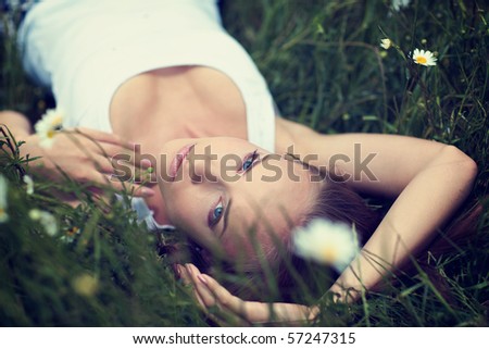Beautiful young girl with diadem on camomile field