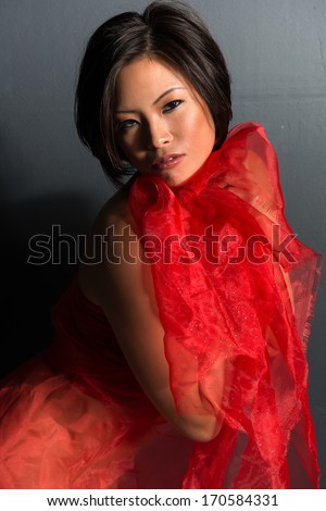 Beautiful young Chinese woman wrapped in red tulle