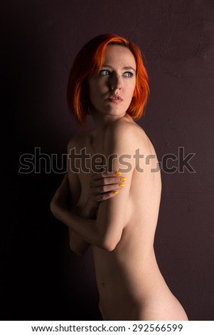 Pretty slim pale nude woman with dyed red hair