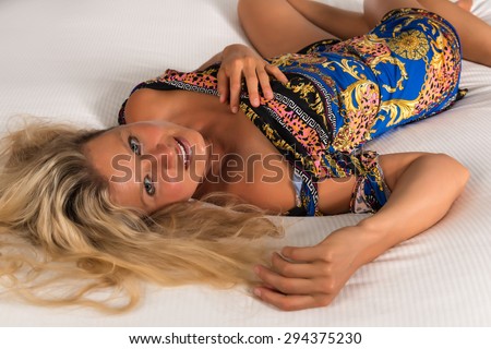 Beautiful statuesque blonde woman in a colorful print dress