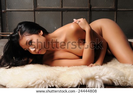 Young Thai woman lying on a sheepskin rug