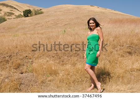 Lovely young brunette in a field of dry brown grass
