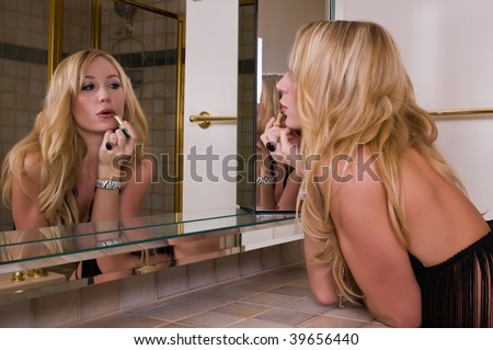 Blonde fashion model works on her makeup