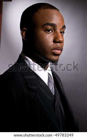 Dramatic portrait of a dignified young black man in a dark suit