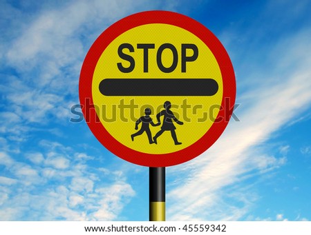 Reflective metallic school crossing patrol \'lollipop\' sign, against a blue sky.