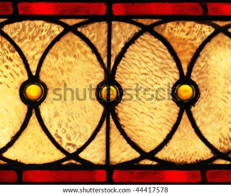 A set of glowing golden circles on a stained glass window.