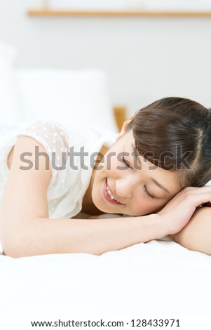 Beautiful asian woman relaxing in bedroom