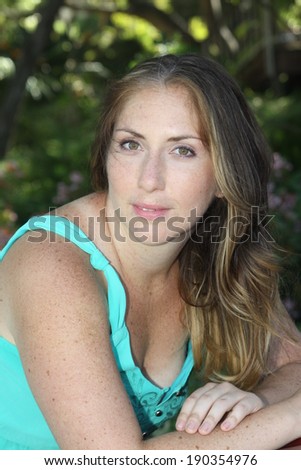 Head shot of a Blond Woman In Turquoise Top