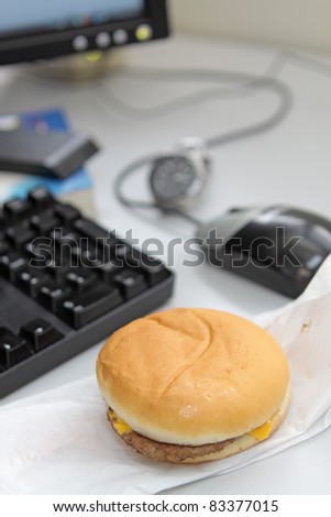 Office business lunch food cheese hamburger, desktop and financial newspaper on office desk
