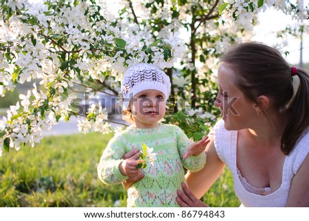 Mum with the child in flowers of an apple-tree