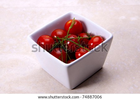 A small bowl of herb tomatoes dressed with a vinaigrette.