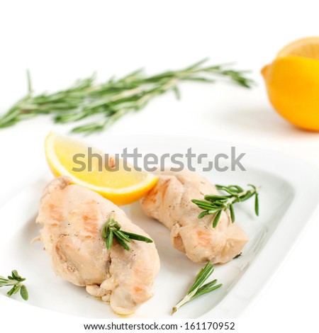 Close up of chicken breast fillet with fresh lemon and rosemary on white plate, square image