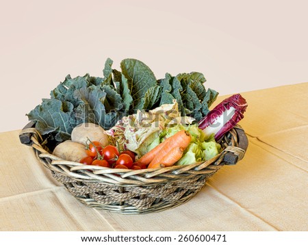 Fresh raw vegetable assortment in woven basket on table. Organic produce.