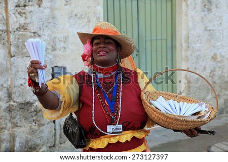 HAVANA, CUBA - FEBRUARY 11:  Cuban woman in colorful clothing selling sweets and peanuts on February 11, 2012 in old Havana, Cuba, for the entertainment of the tourists.