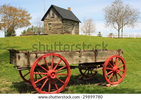 Pioneer wagon and restored log cabin on a farm in rural Michigan