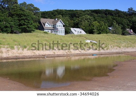 Attractive summer cottage on the shores of Lake Michigan, with reflection in a tide pool