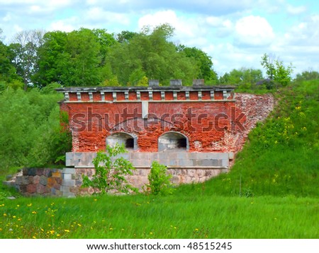Landscape with a fortress, green grass, dandelions and blue sky