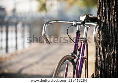Road bicycle on city street, cycling in summer nature, vintage old retro bike, cycling or commuting in city urban environment, ecological transportation concept