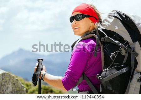 Woman hiking with backpack in mountains, Corsica France. Success and achievement, sport, exercising outdoors in summer nature