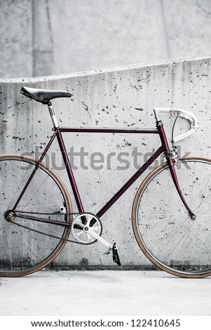City bicycle fixed gear and concrete wall. Vintage style bike and gray industrial building