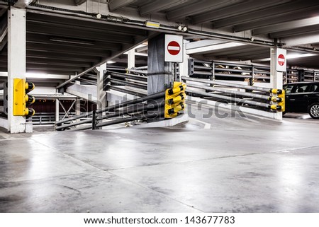 Parking garage lot, urban scene at night in city and cars on parking lot. Dark and grunge construction interior.