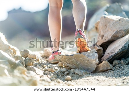 Walking or running legs on trail, adventure and exercising in mountains nature, runners sports shoe on dirt road