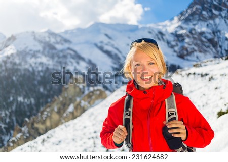 Woman hiker nordic walking in Himalaya Mountains in Nepal. Trekking on snow white winter nature, beautiful mountain landscape.