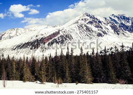 Winter landscape in beautiful Tatra Mountains. White mountain ridge with snow over blue sunny sky in Poland