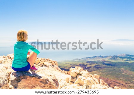 Young woman looking and meditation outside natural beautiful inspirational landscape environment, fitness and exercising motivation and inspiration in sunny mountains over blue sky and ocean sea.