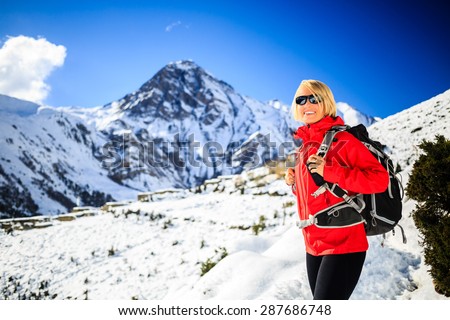 Woman hiker nordic walking, healthy lifestyle in Himalaya Mountains in Nepal. Trekking and hiking on snow white winter nature, beautiful inspirational mountain landscape.