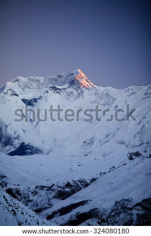 Mountain inspirational landscape in Himalayas, Annapurna 2, Nepal. Mountain ridge with ice and snow over clear blue night sky.