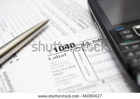 Tax forms, mobile phone and silver pen.