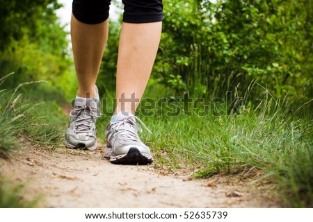 Woman walking cross country and trail in spring forest