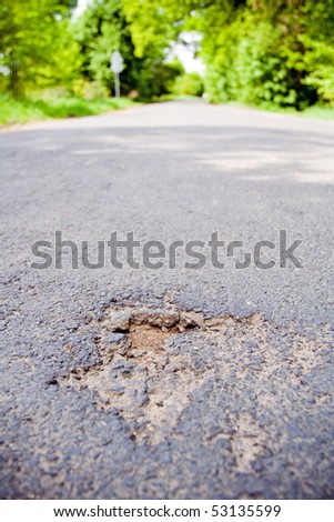 Road with holes in spring. Damaged by cold in winter