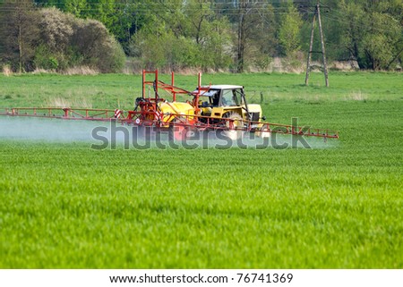 Tractor spraying a crop field on farm