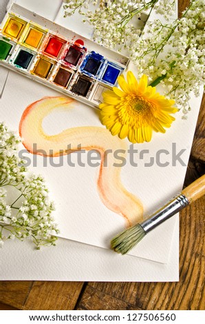 still life of watercolor paint with brush and flowers