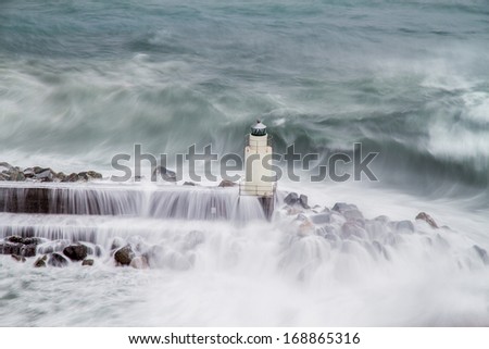 Powerful waves heating the lighthouse of Camogli during a sea storm