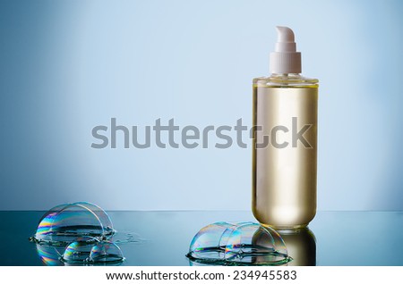 Beautiful bottle of liquid cleanser with soap bubble on a reflective surface.