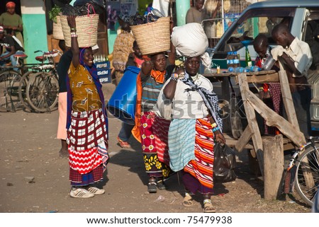 ARUSHA, TANZANIA - AUGUST 11: Unidentified woman at a crowded local market near Arusha, Tanzania, on august 11, 2010. Woman usually carry their merchandise in big baskets on their heads
