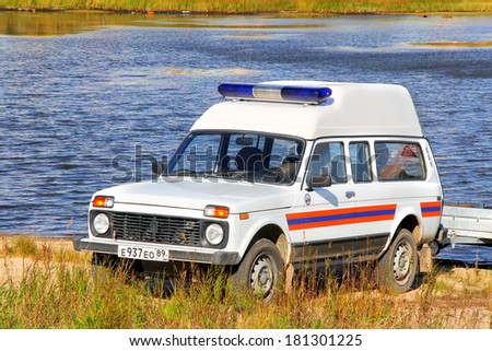 NOVYY URENGOY, RUSSIA - SEPTEMBER 2, 2012: White emergency LADA Niva vehicle near a town pond.
