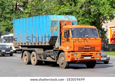 UFA, RUSSIA - JUNE 25, 2012: Orange and cyan KAMAZ 6520 container garbage truck at the city street.
