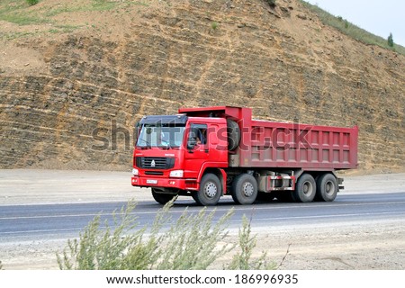 SIM, RUSSIA - AUGUST 14, 2008: Red CNHTC Howo Sinotruk dump truck at the interurban road.