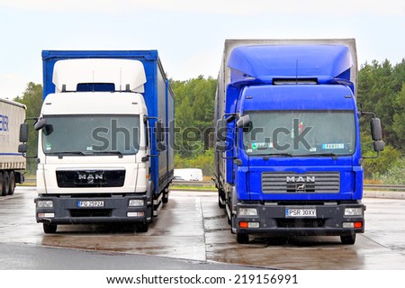 GERMANY - AUGUST 14, 2014: White and blue trucks MAN TGM at the interurban road,